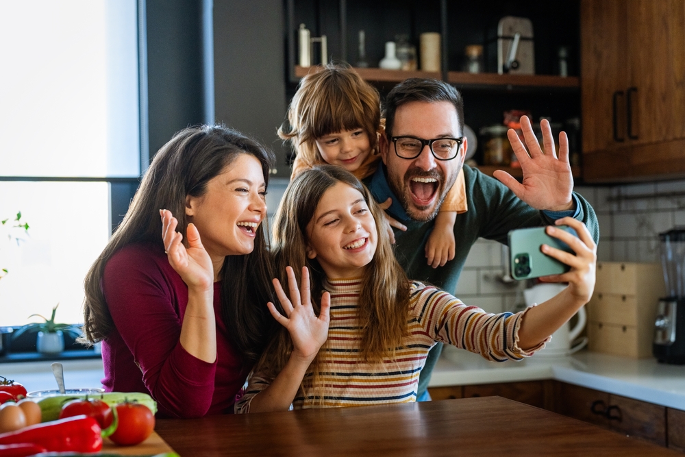Happy,Parents,With,Children,Using,Smartphone,Together,At,Home.,Family